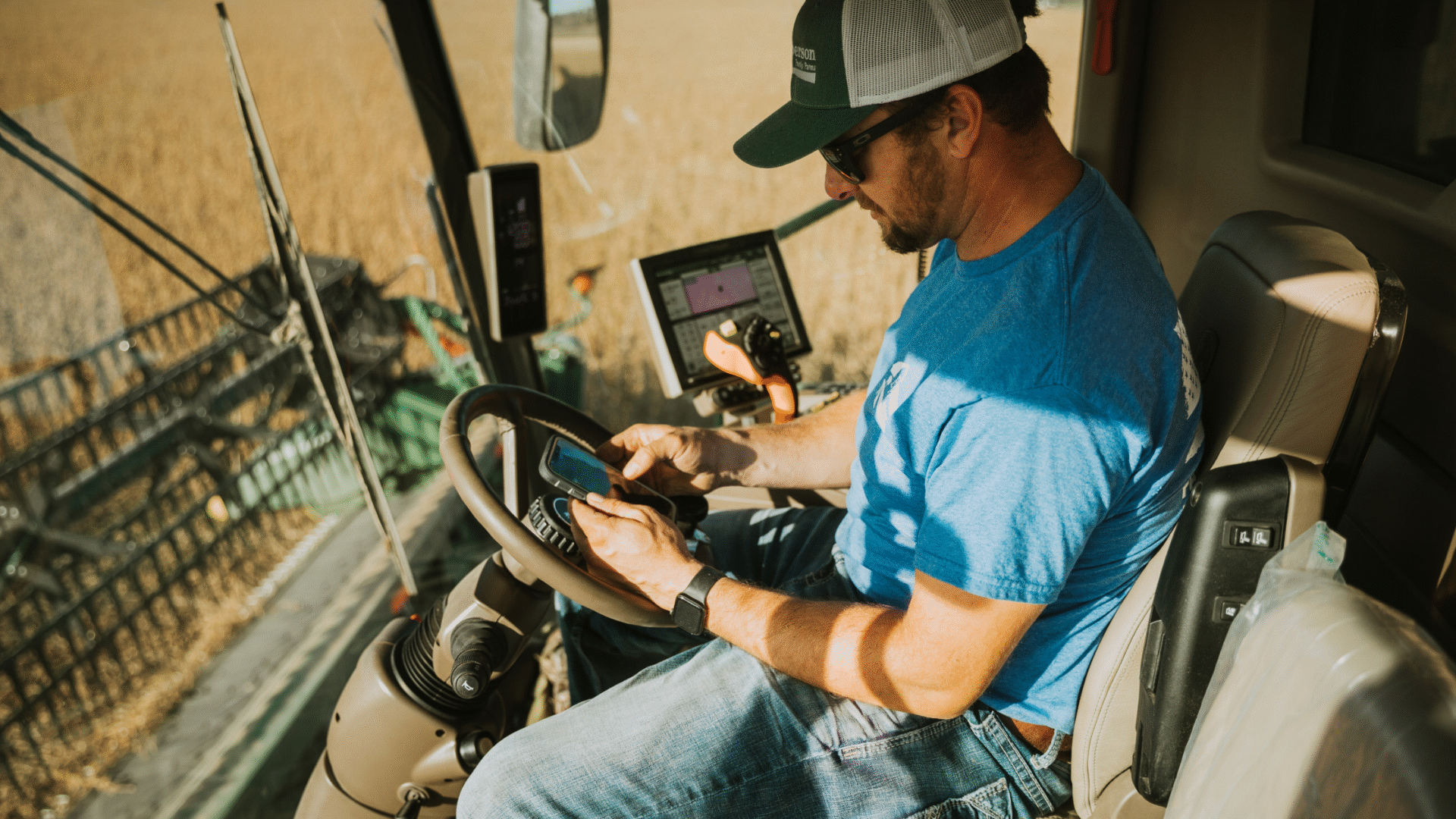 farmer on phone in combine harvesting